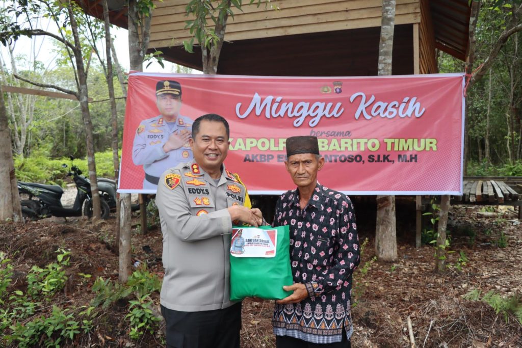 Alt : Kapolres Bartim menyerahkan bingkisan saat minggu Kasih di Danau Dayu, Desa Dayu Kecamatan Karisen Janang. Minggu (12/1/2025).